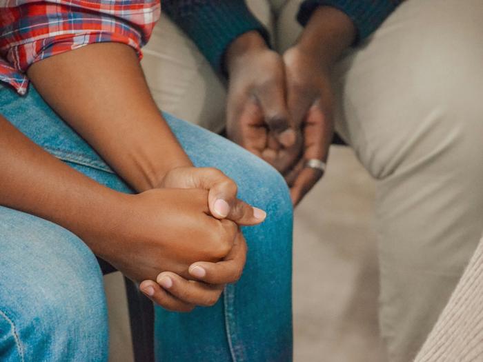 Two people holding hands in a gesture of comfort and support